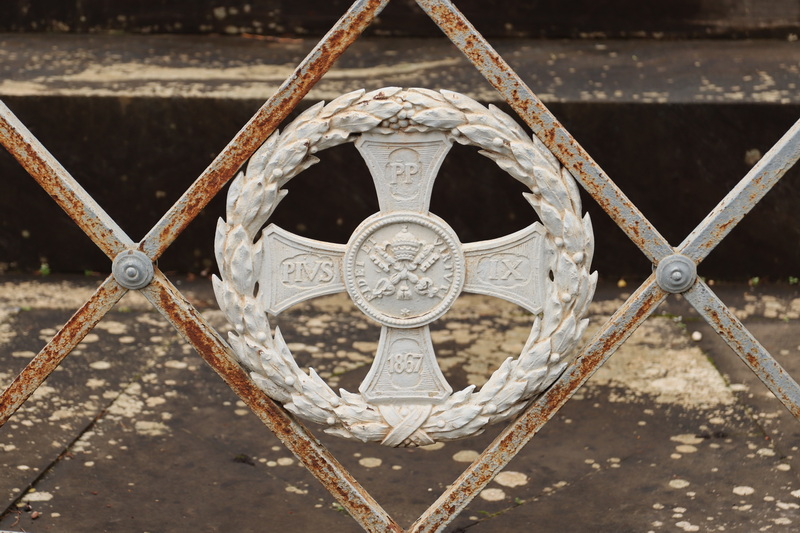 The papal coat of arms on the fencing around the monument on Campo Verano.